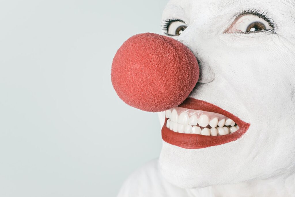 Smiling Person With Pink Lipstick and Red Nose Clown