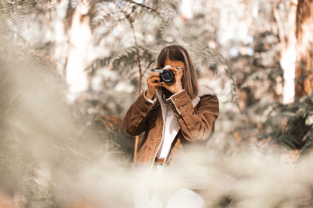 Woman in Brown Coat Holding Black Camera