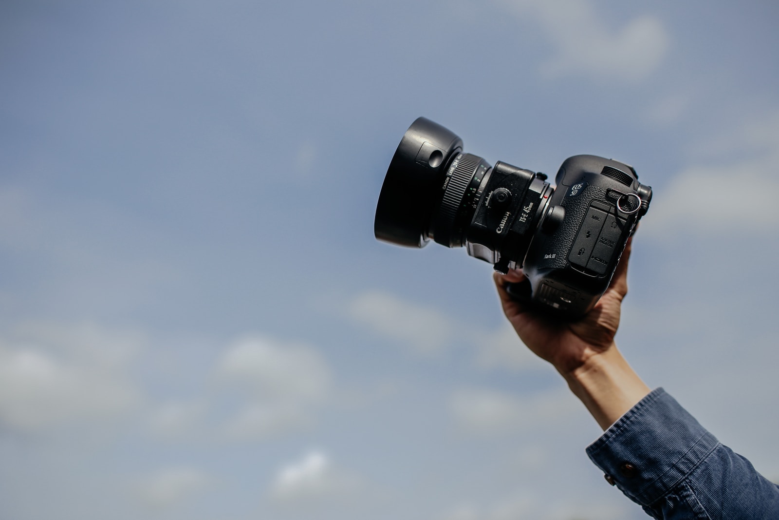 man using his black DSLR camera