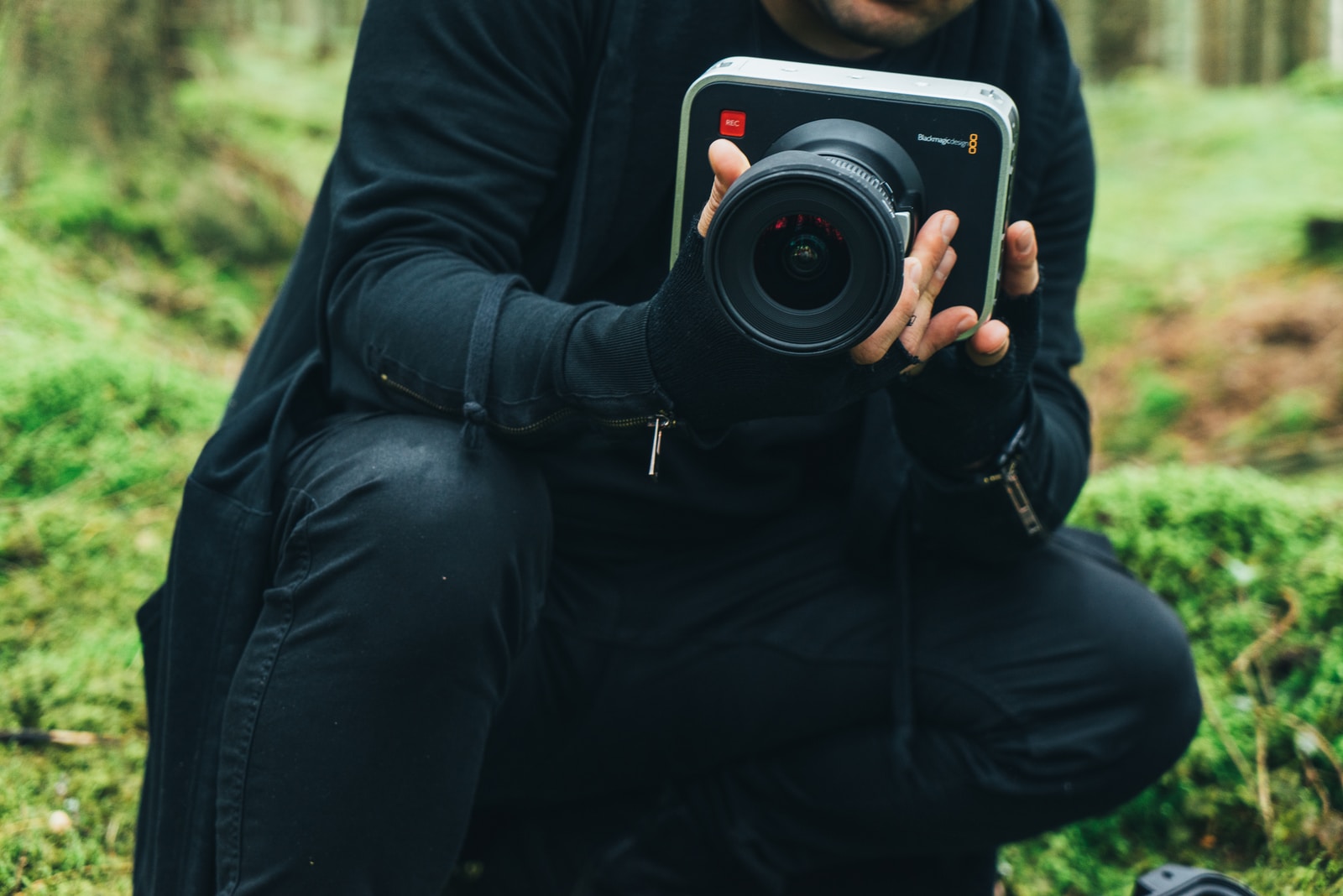 man in black jacket holding DSLR camera