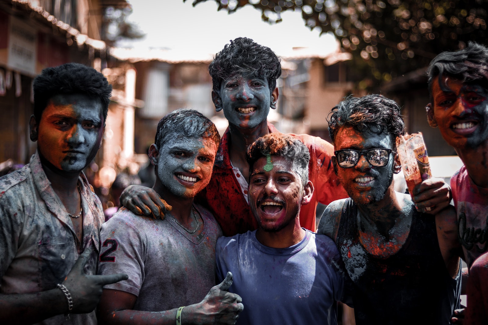 Group of men with faces and body covered with coloured powder
