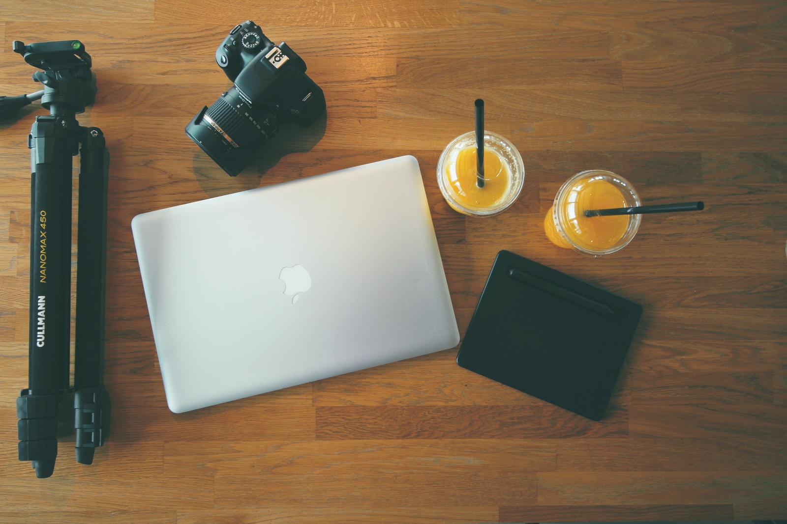 gray MacBook beside DSLR camera