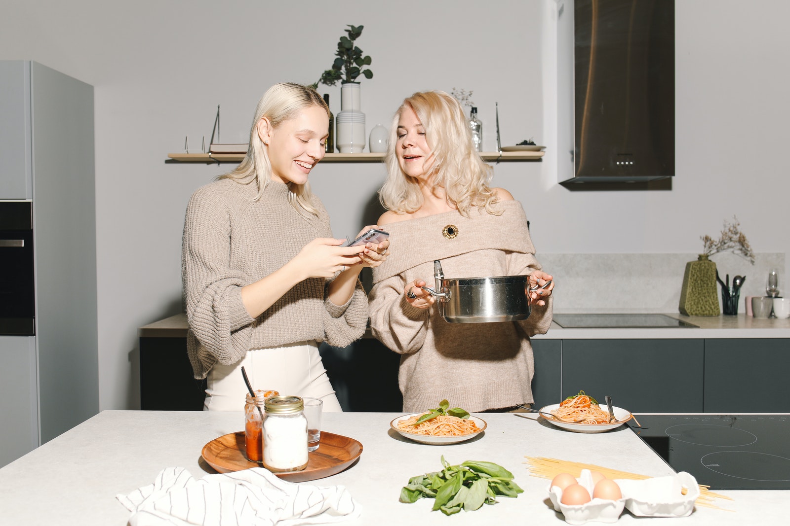 Photo Of Mother Holding A Pot While Daughter Is Looking At Her Phone