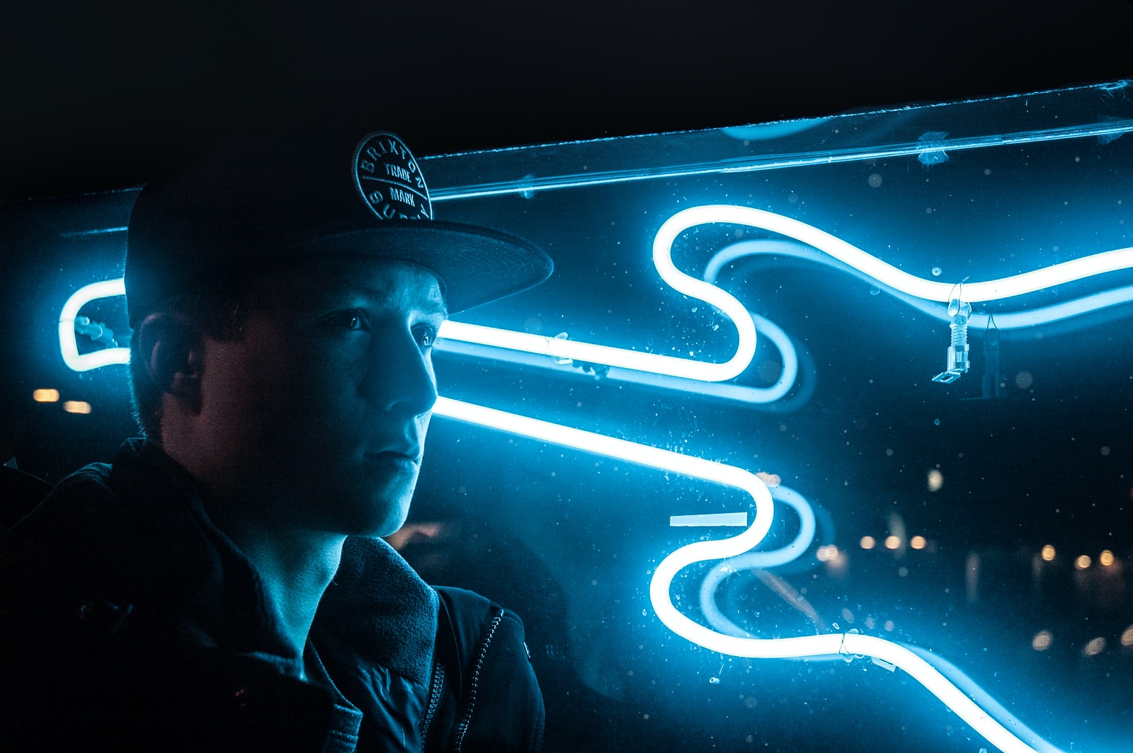 Man In Black Jacket Beside Blue Neon Light Guitar