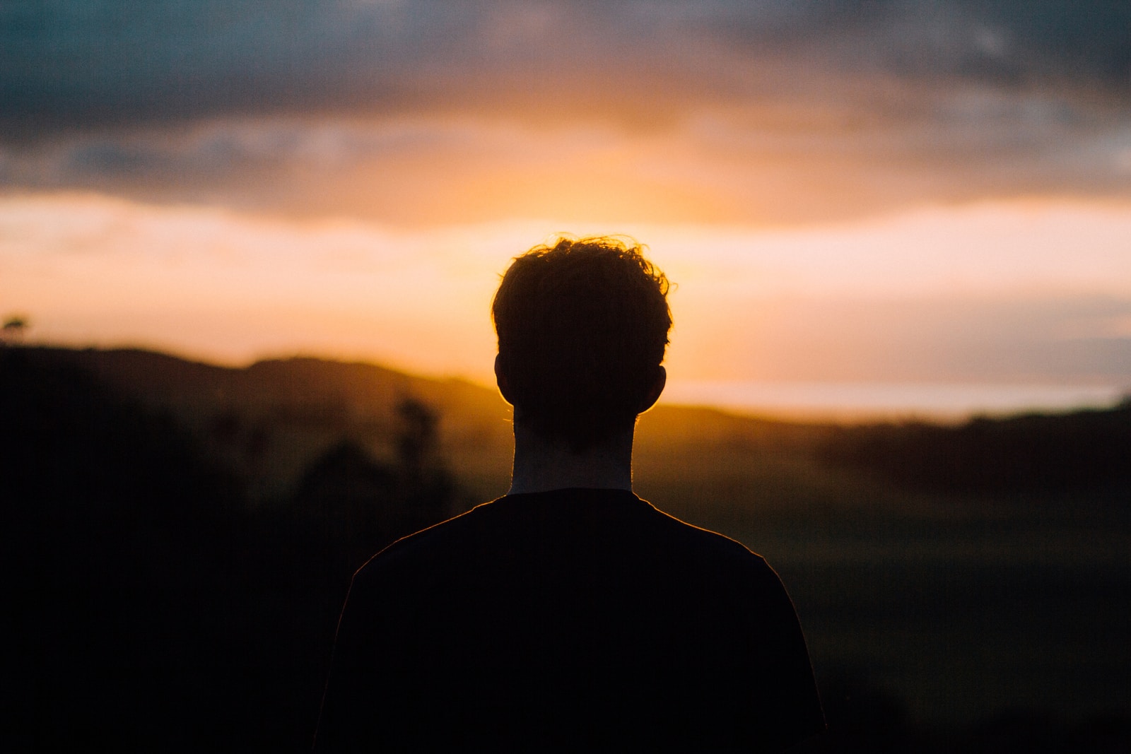 silhouette of a man facing the sunset