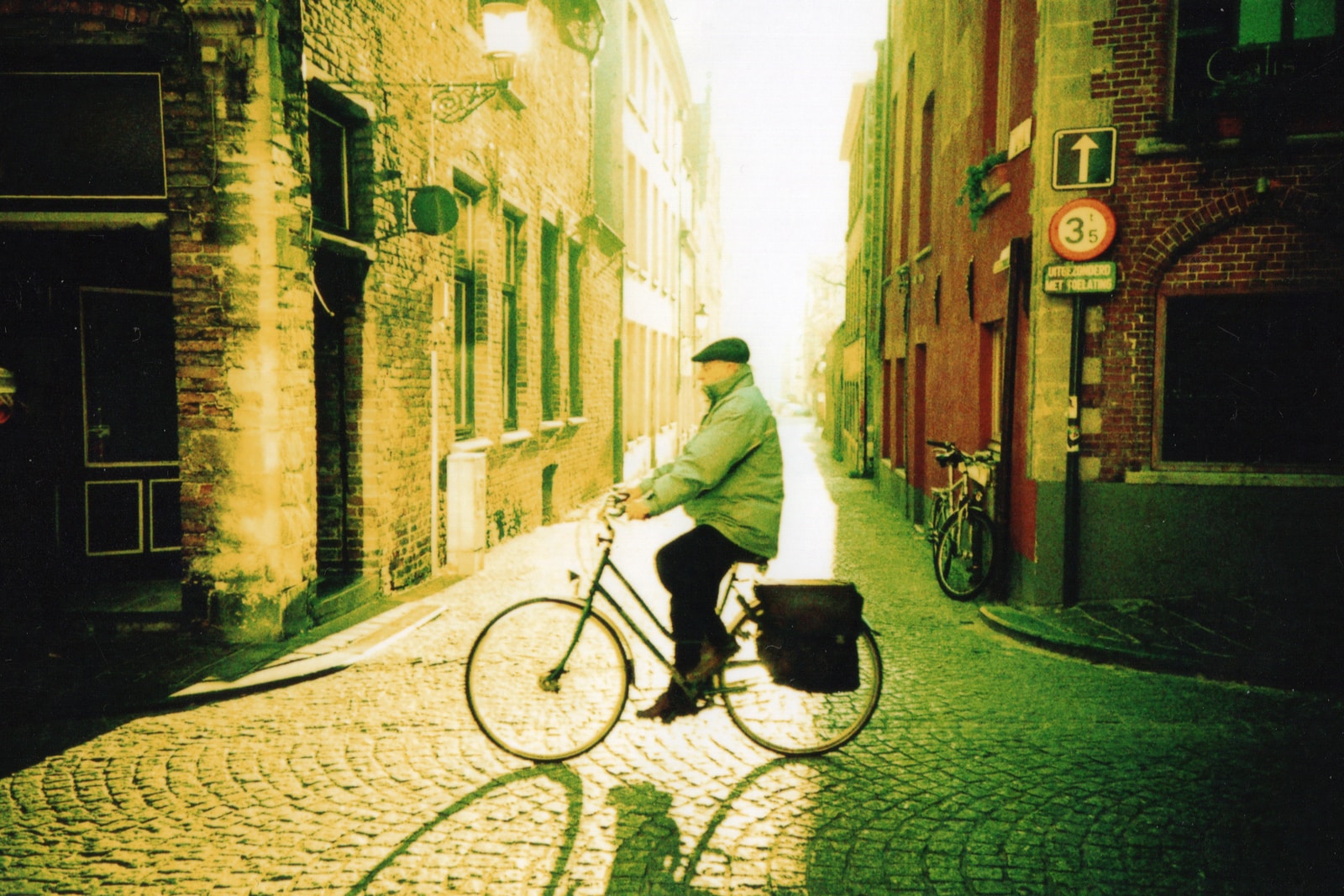 man in white hoodie riding on bicycle on street during daytime