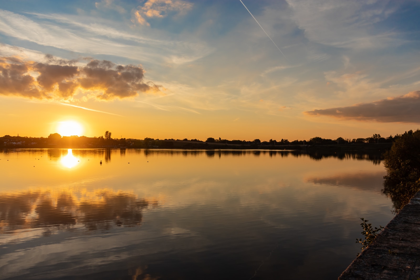 body of water under cloudy sky during sunset