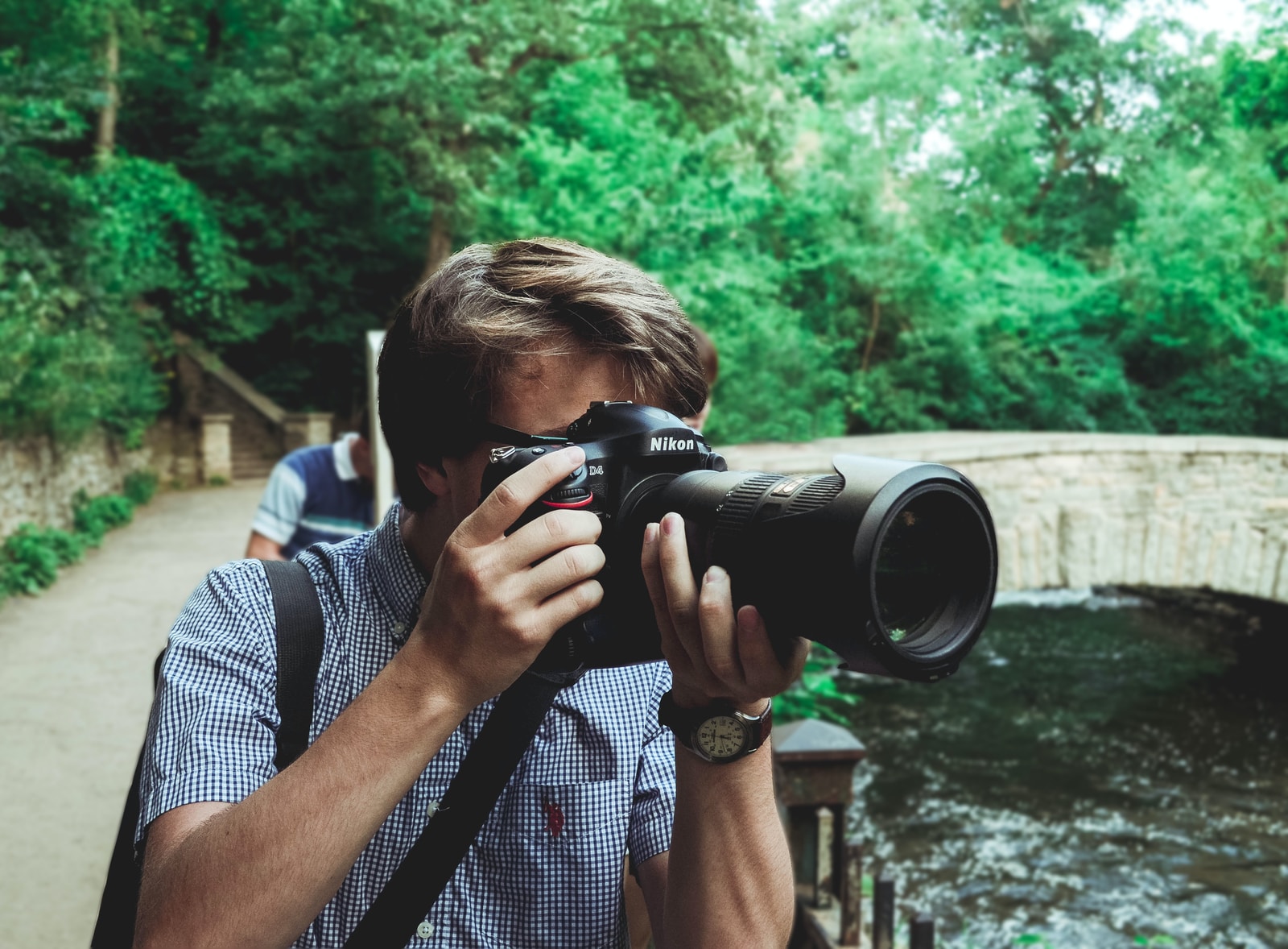 man taking photo using black Nikon DSLR camera